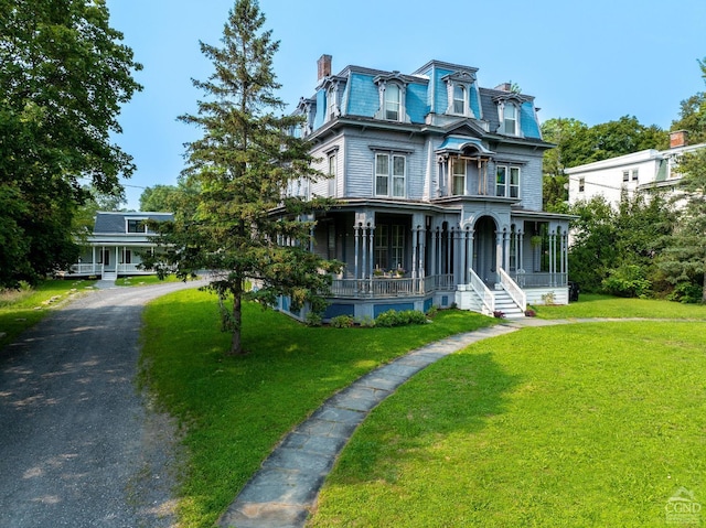 view of front facade featuring covered porch and a front yard