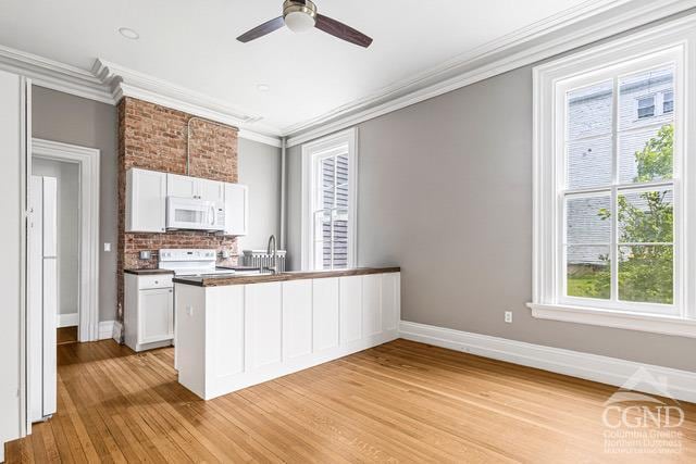 kitchen with white cabinetry, plenty of natural light, light hardwood / wood-style floors, and white appliances