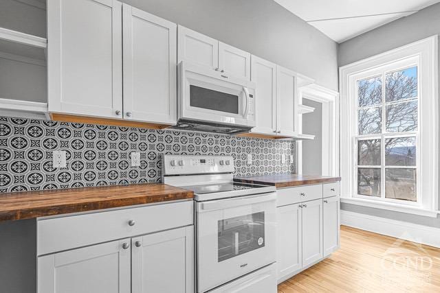 kitchen featuring white cabinets, decorative backsplash, white appliances, and butcher block counters