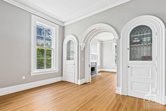 unfurnished dining area with crown molding and light wood-type flooring