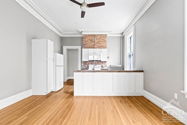 kitchen featuring white appliances, white cabinets, ceiling fan, ornamental molding, and light hardwood / wood-style floors