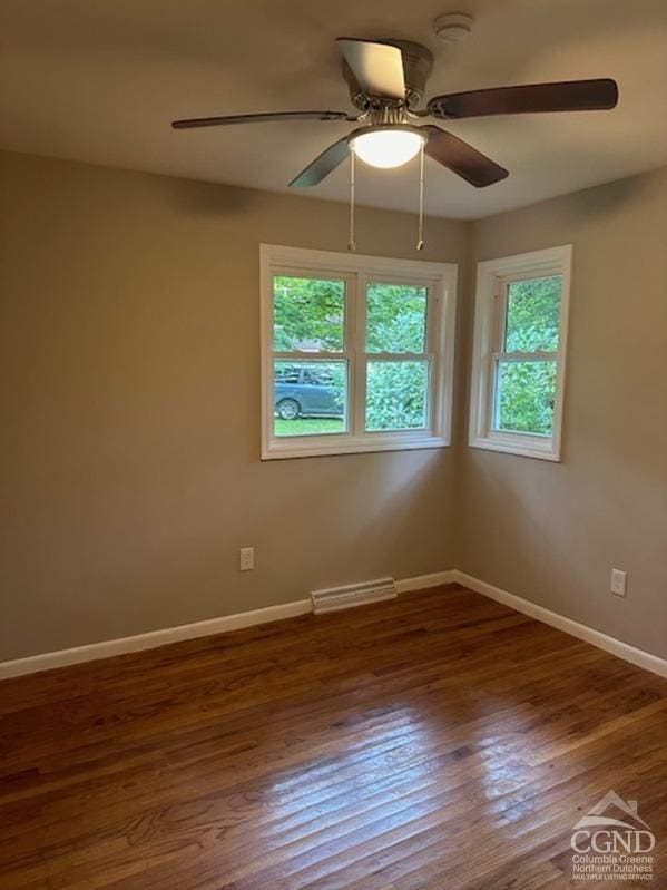 unfurnished room with ceiling fan and dark wood-type flooring