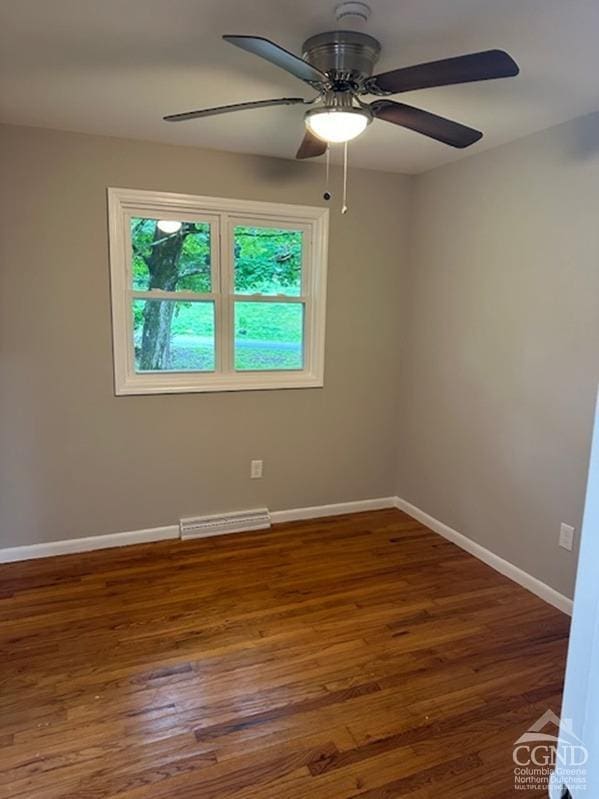 spare room featuring ceiling fan and dark wood-type flooring