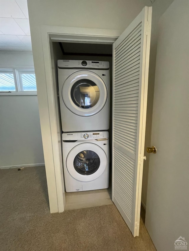 washroom featuring carpet flooring, stacked washer / dryer, and laundry area