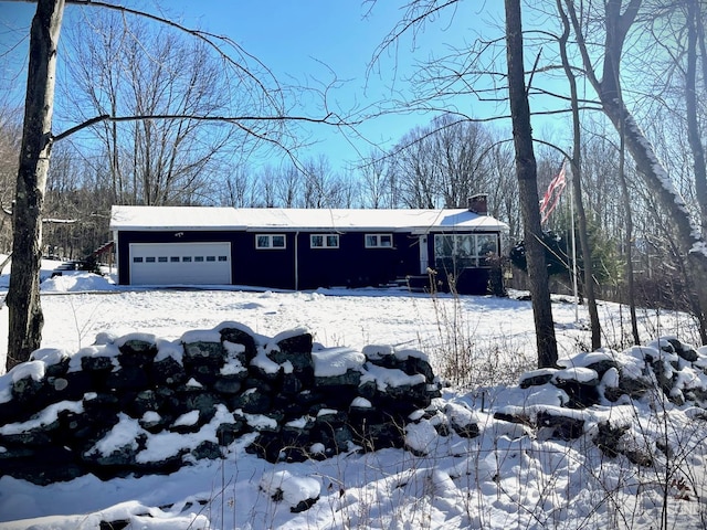 ranch-style home with an attached garage and a chimney