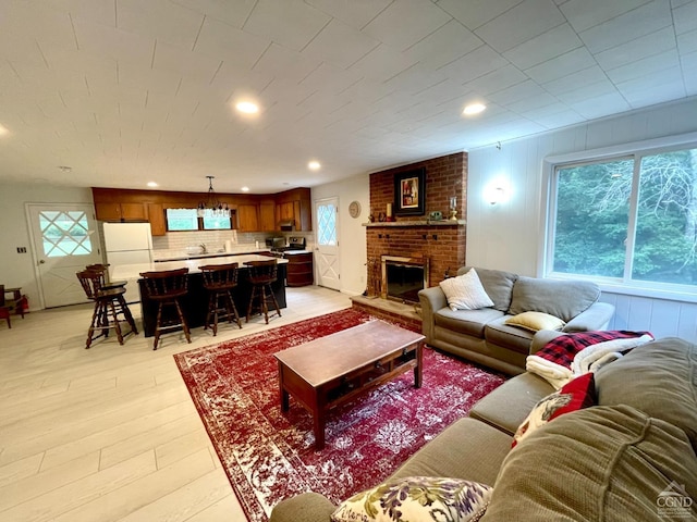 living area with a fireplace, recessed lighting, and light wood-type flooring