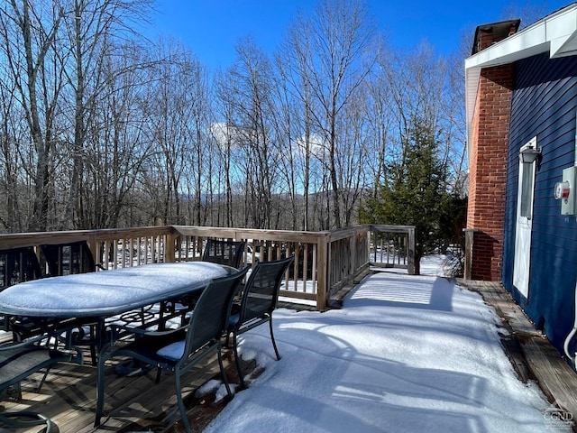 snow covered deck featuring outdoor dining area