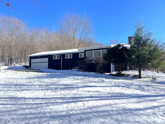 view of front of property featuring a chimney and an attached garage