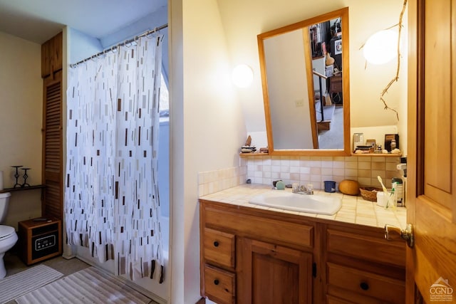 bathroom with vanity, tasteful backsplash, and toilet