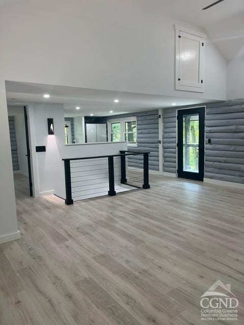 rec room with vaulted ceiling, a wealth of natural light, and light hardwood / wood-style flooring