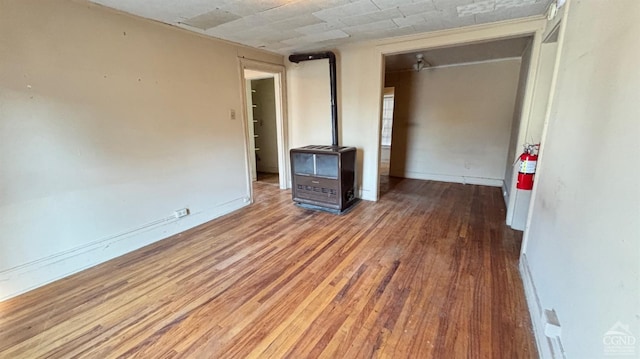 unfurnished living room featuring heating unit and hardwood / wood-style flooring