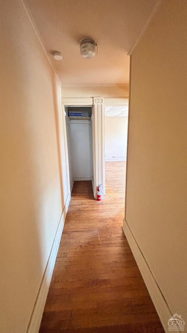 hall featuring crown molding and light hardwood / wood-style flooring