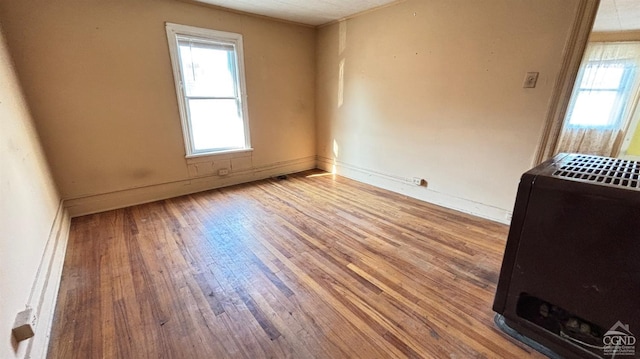 unfurnished room with hardwood / wood-style flooring and heating unit