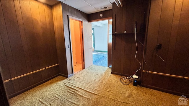 corridor featuring carpet and wooden walls