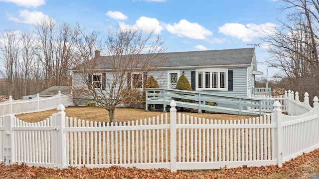 view of front facade featuring a wooden deck, a fenced backyard, driveway, and a gate