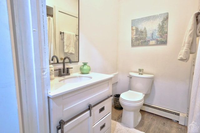 bathroom with wood-type flooring, vanity, a baseboard radiator, and toilet