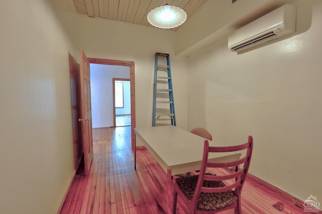 hallway featuring light hardwood / wood-style flooring and a wall mounted air conditioner