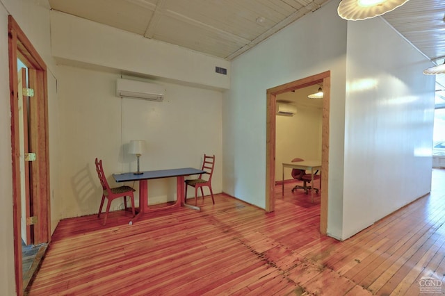 corridor featuring a wall mounted air conditioner and hardwood / wood-style flooring