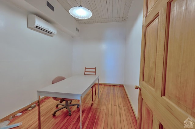 office space featuring a wall mounted AC and light wood-type flooring