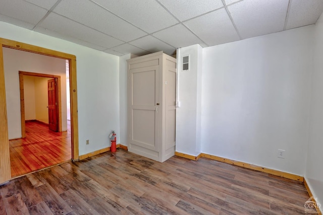 spare room with hardwood / wood-style floors and a paneled ceiling