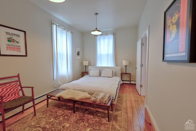 bedroom with wood-type flooring and baseboard heating