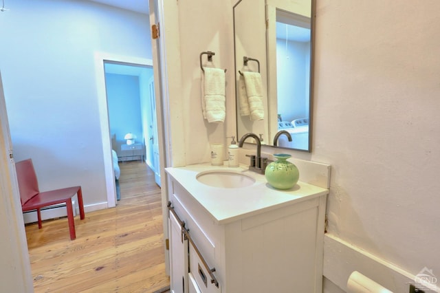 bathroom with baseboard heating, vanity, and hardwood / wood-style flooring