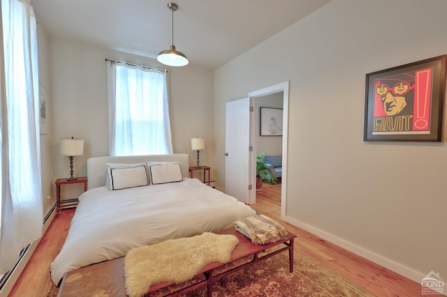 bedroom with wood-type flooring and baseboard heating