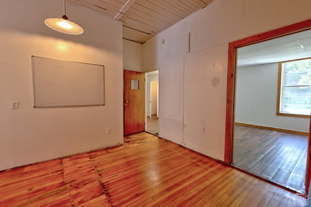 empty room featuring light wood-type flooring and a high ceiling