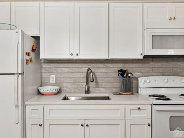 kitchen featuring white cabinets, white appliances, and sink