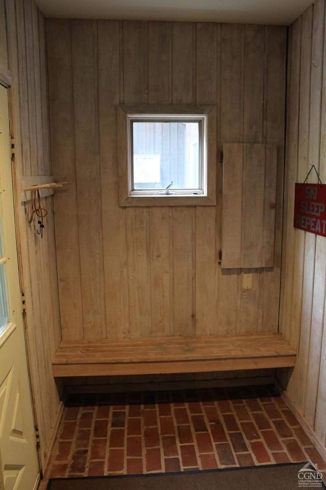 mudroom featuring brick floor, wooden walls, and a sauna