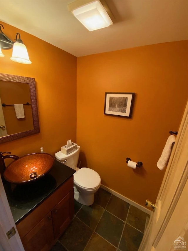 bathroom featuring baseboards, vanity, toilet, and tile patterned floors