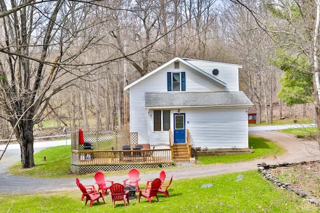 rear view of house featuring a lawn and an outdoor fire pit