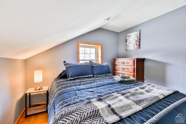 bedroom featuring hardwood / wood-style floors and vaulted ceiling