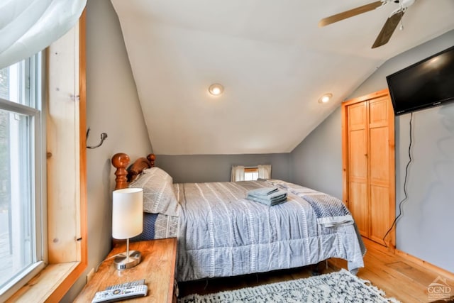 bedroom with ceiling fan, hardwood / wood-style floors, and vaulted ceiling