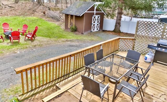 wooden deck featuring a grill and a storage shed