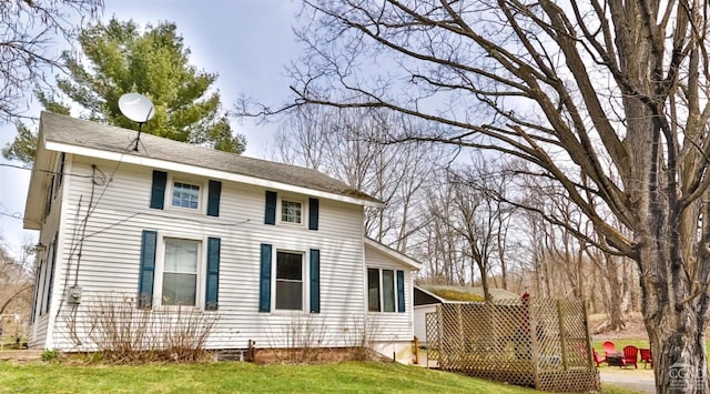 view of side of home with a yard