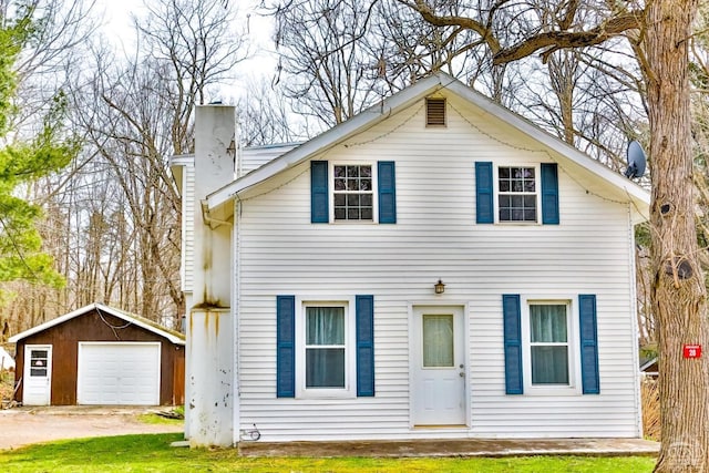 view of front facade featuring a garage, an outdoor structure, and a front yard