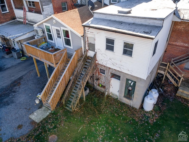 rear view of property featuring central AC unit and an AC wall unit