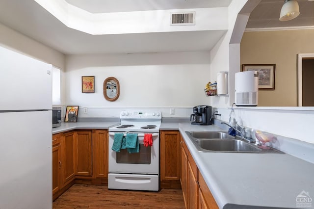 kitchen featuring sink, dark hardwood / wood-style floors, and white appliances