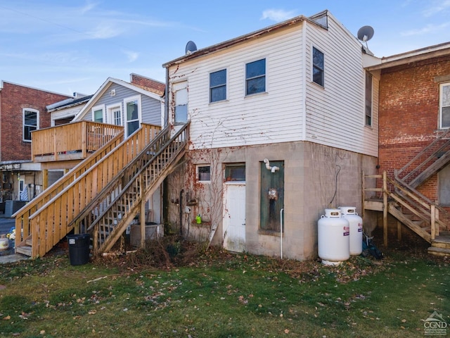 rear view of property featuring a yard and central air condition unit