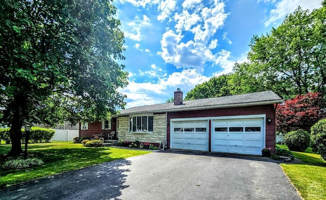 single story home featuring a front yard, driveway, a chimney, stone siding, and a garage