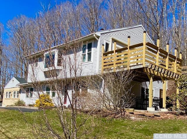 rear view of house featuring a wooden deck