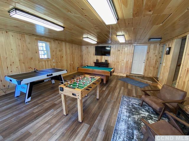 rec room featuring hardwood / wood-style flooring, wooden ceiling, wooden walls, and pool table