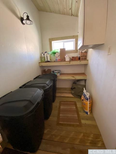 clothes washing area featuring washing machine and dryer, wooden ceiling, and wood-type flooring