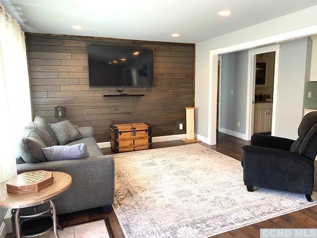 living room with wooden walls and hardwood / wood-style flooring