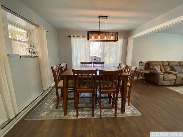 dining space featuring a chandelier, dark wood-type flooring, and a healthy amount of sunlight