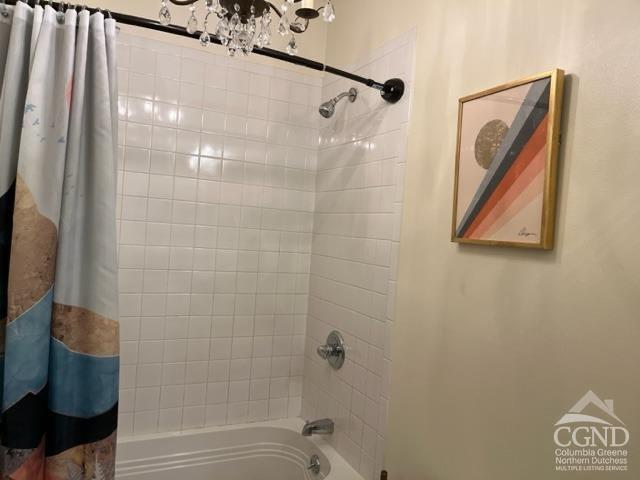 bathroom with shower / bath combination with curtain