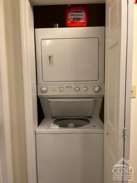 washroom with stacked washing maching and dryer