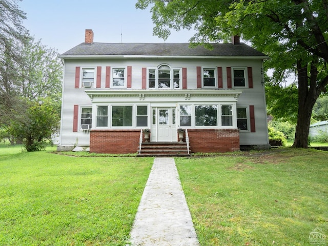 colonial house featuring a sunroom, cooling unit, and a front lawn