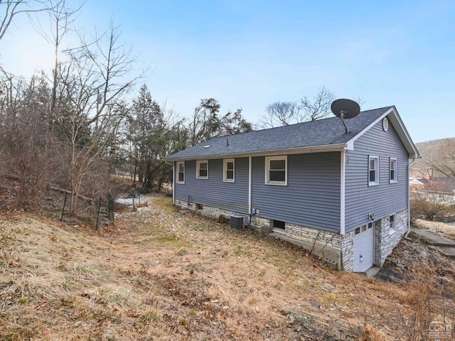 view of side of property with a garage and central AC